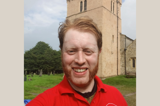 Matthew Maries, of the National Churches Trust, standing in front of a church tower