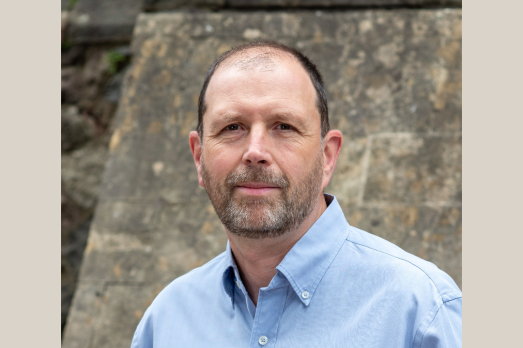 Gareth Simpson, of the National Churches Trust, standing in front of a stone wall