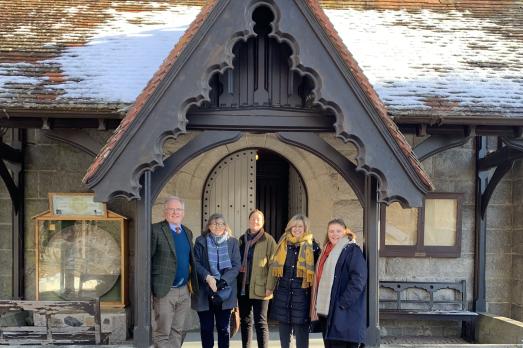 An image of five people standing in the porch at Crathie Kirk in Scotland