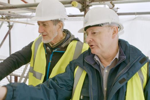 Two men wearing high-vis jackets and hard hats