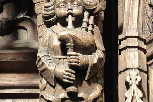 A carved wooden angel playing the bagpipes