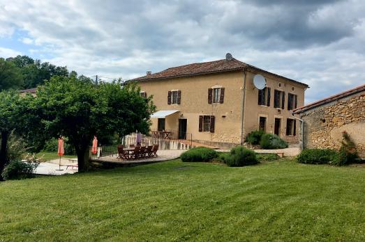 A large farmhouse behind a lawn