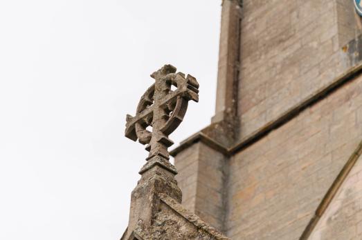 A stone cross on a church building