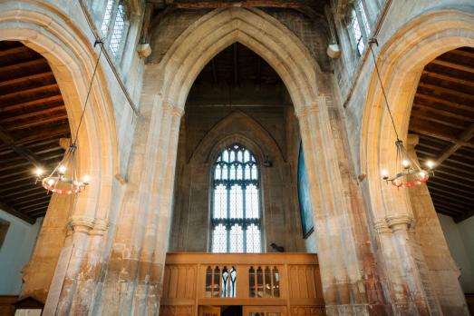 Three beautiful archways inside the church. You can see a large arched window too