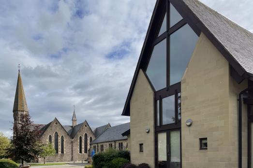 A modern church hall attached to an older church