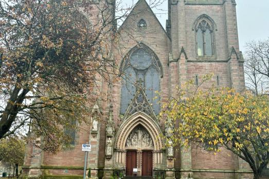 A photo of exterior and entrance of Inverness Cathedral; two towers dominate either side of the doorway.