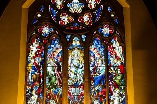 A beautiful stained glass window with many panels and colours. 