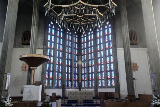 Inside a church, looking at a large stained glass window