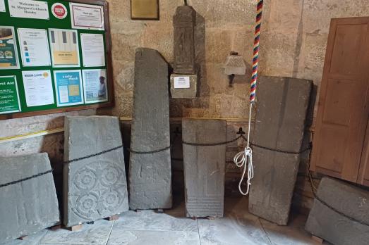 Stones laid against an internal wall near a noticeboard