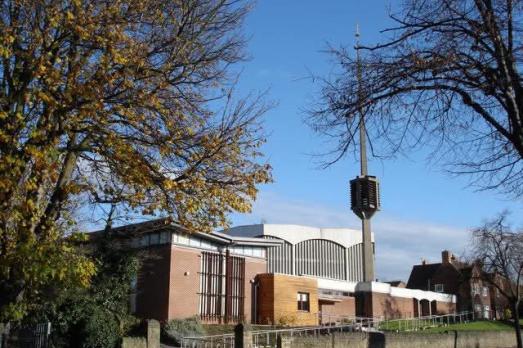 A striking concrete building with a unique concrete spire. 
