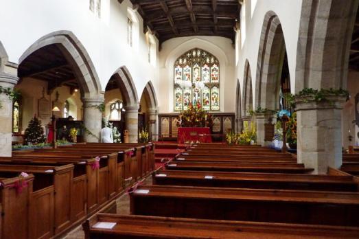 Beautiful interior of St Oswald. Rows of pews facing the altar.