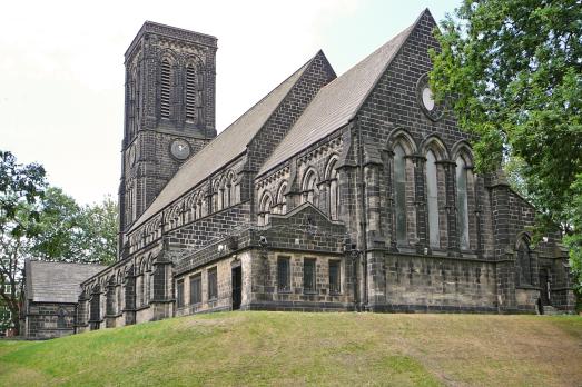A large early Gothic Revival stone church  photograph from below the hill in which it sits on.