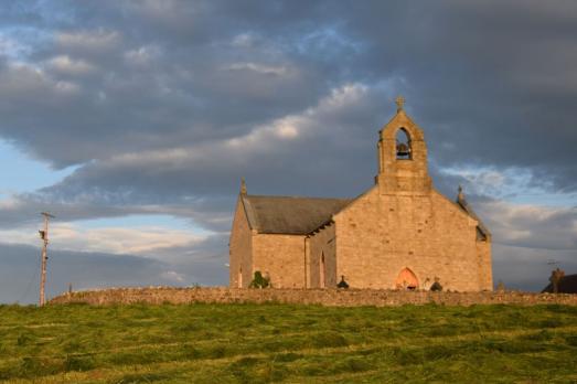 St Macartans (the forth chapel) in Augher, County Tyrone with blue and cloudy skies in the background.
