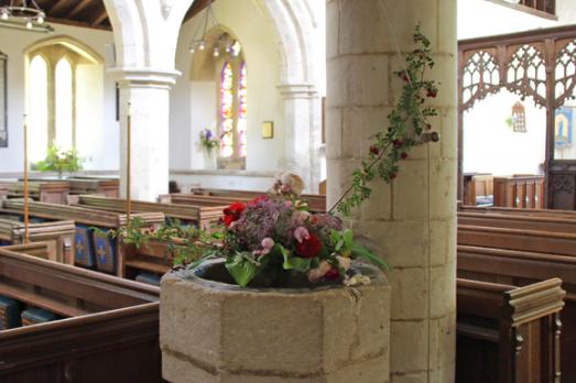 A font filled with flowers inside a church.