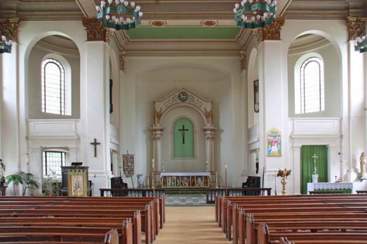 The interior of All Saints in Poplar facing a beautiful altar with arched windows either side