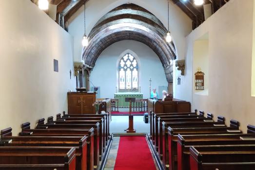 Rows of wooden pews facing an altar