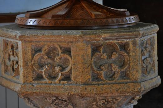 A close up of the intricately carved stone font