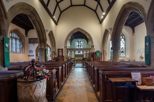 The interior of St Peter & St Paul; rows of pews face an altar