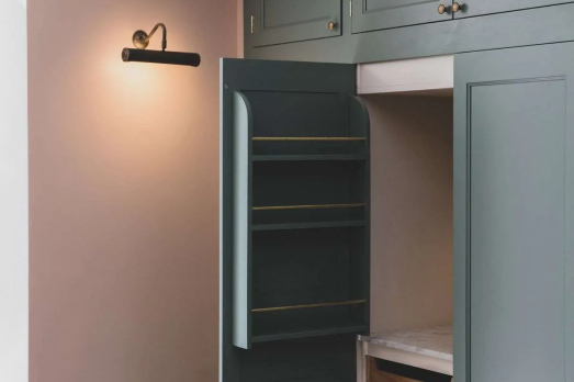 The image shows a kitchen area. The Cabinets are pale blue with a darker green door opening with shelves inside.