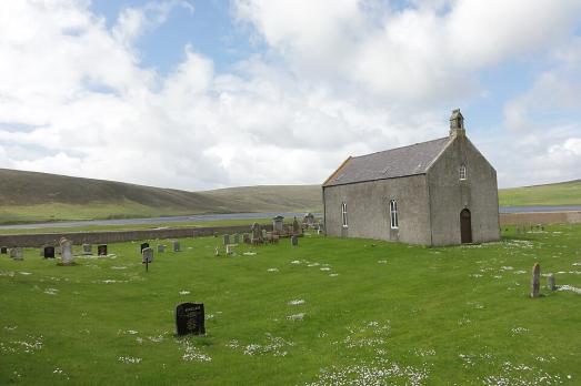 A small kirk in a green field.