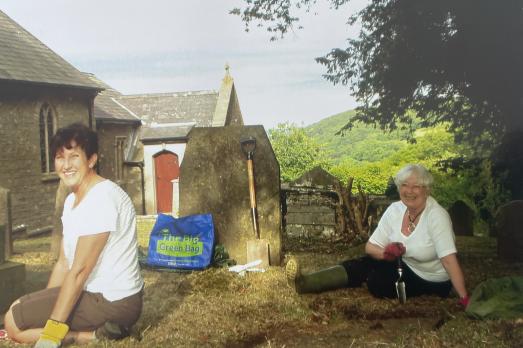 Two women sitting in a churchyard