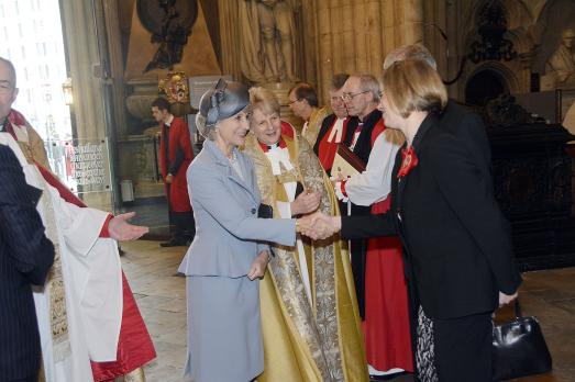 A line of people standing in front of a woman as she shakes hands with them
