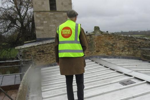 A man walking on the roof of a church