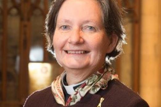 A woman inside a church wearing a purple jumper