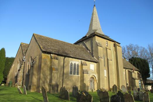 A yellow-stone church on a clear day