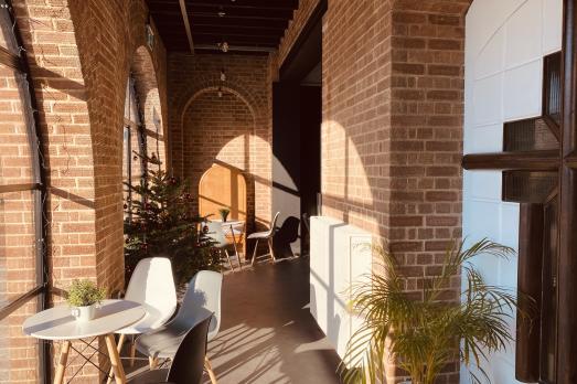 A church hallway with brick walls and a table and chairs