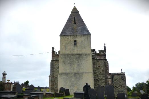 A striking church with a pointed tower roof towers above the landscape