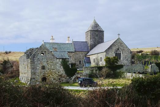A historic old stone church with some stone buildings next to it