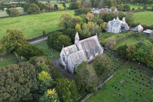 A drone shot of Holy Trinity - a small rural church surrounded by countryside