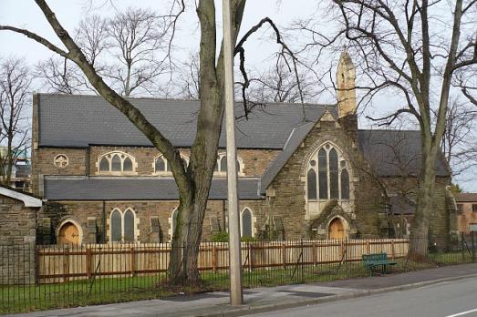 A handsome stone church is behind a low wall