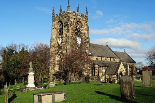 A stone church sat on a hill with a large square tower