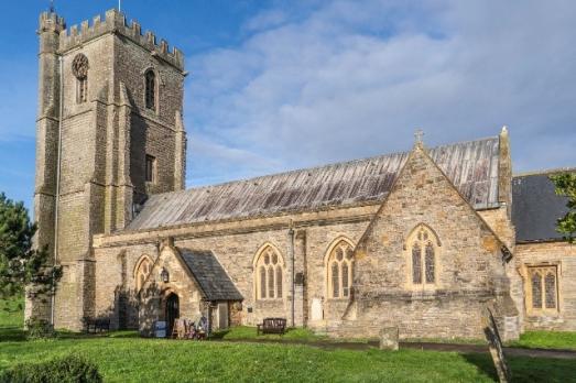 A light stone Somerset church with a prominent tower on the left