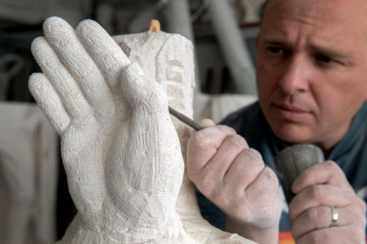 Man carving stone hand