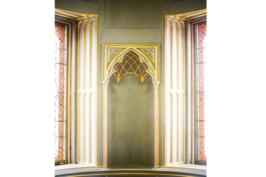 Stonework in a church with a stained glass window in the background