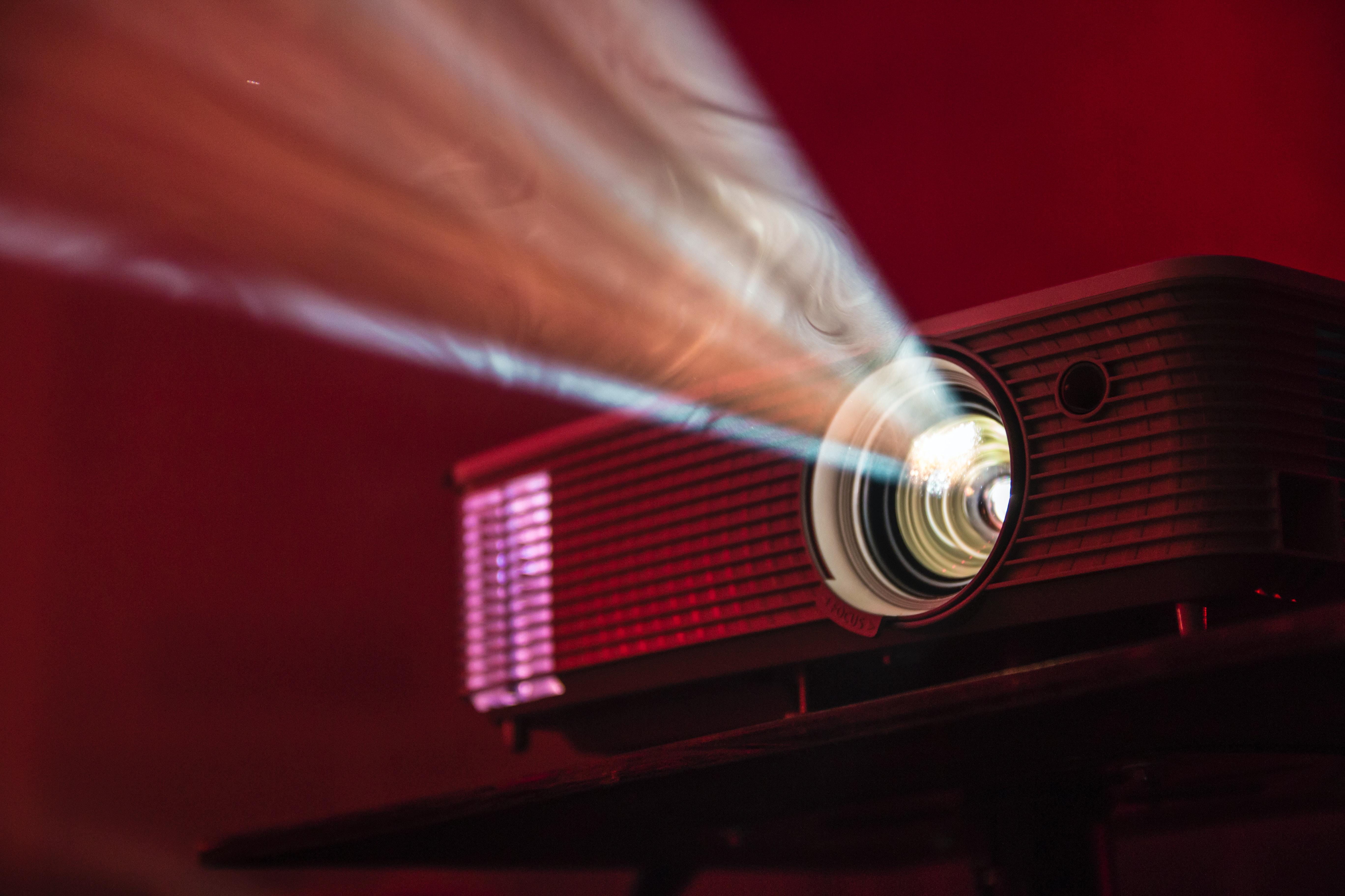 An up-close image of a projector in a dark red room
