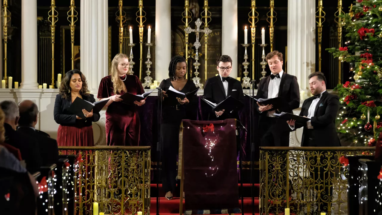 A group of singers, performing carols in a church