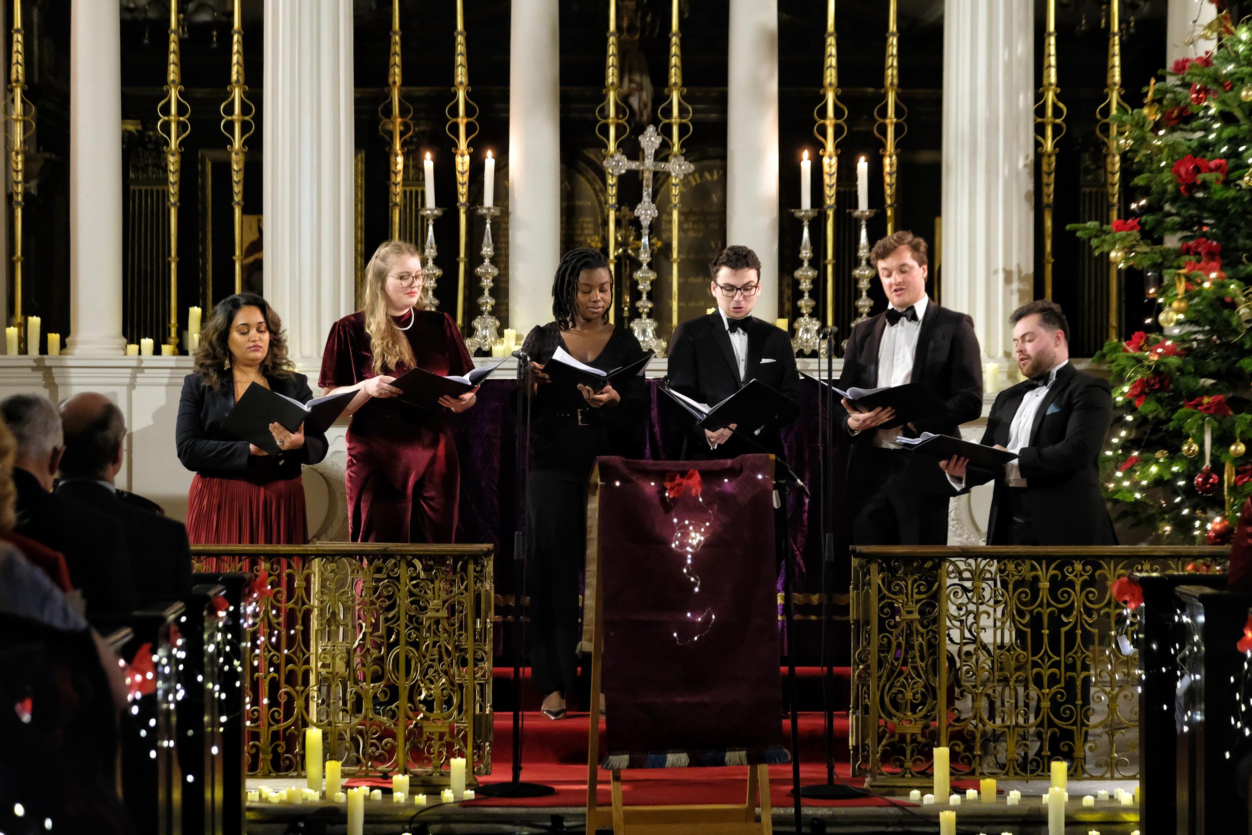A group of singers, performing carols in a church