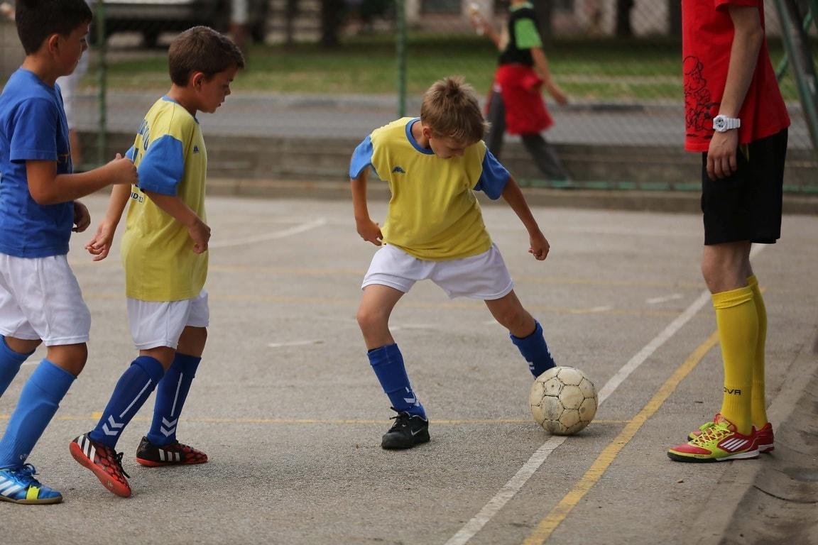 Three children play football
