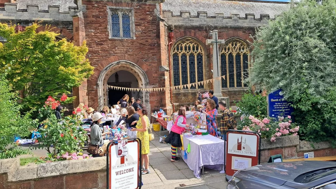 Totnes St Mary with tables and volunteers outside and a welcome sign
