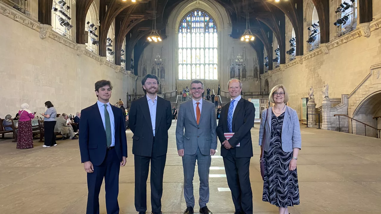 The National Churches Trust Public Affairs and Policy Team with our Chair, Sir Philip Rutnam, and Chief Executive Claire Walker inside Westminster Hall. A large arched window is behind the team.