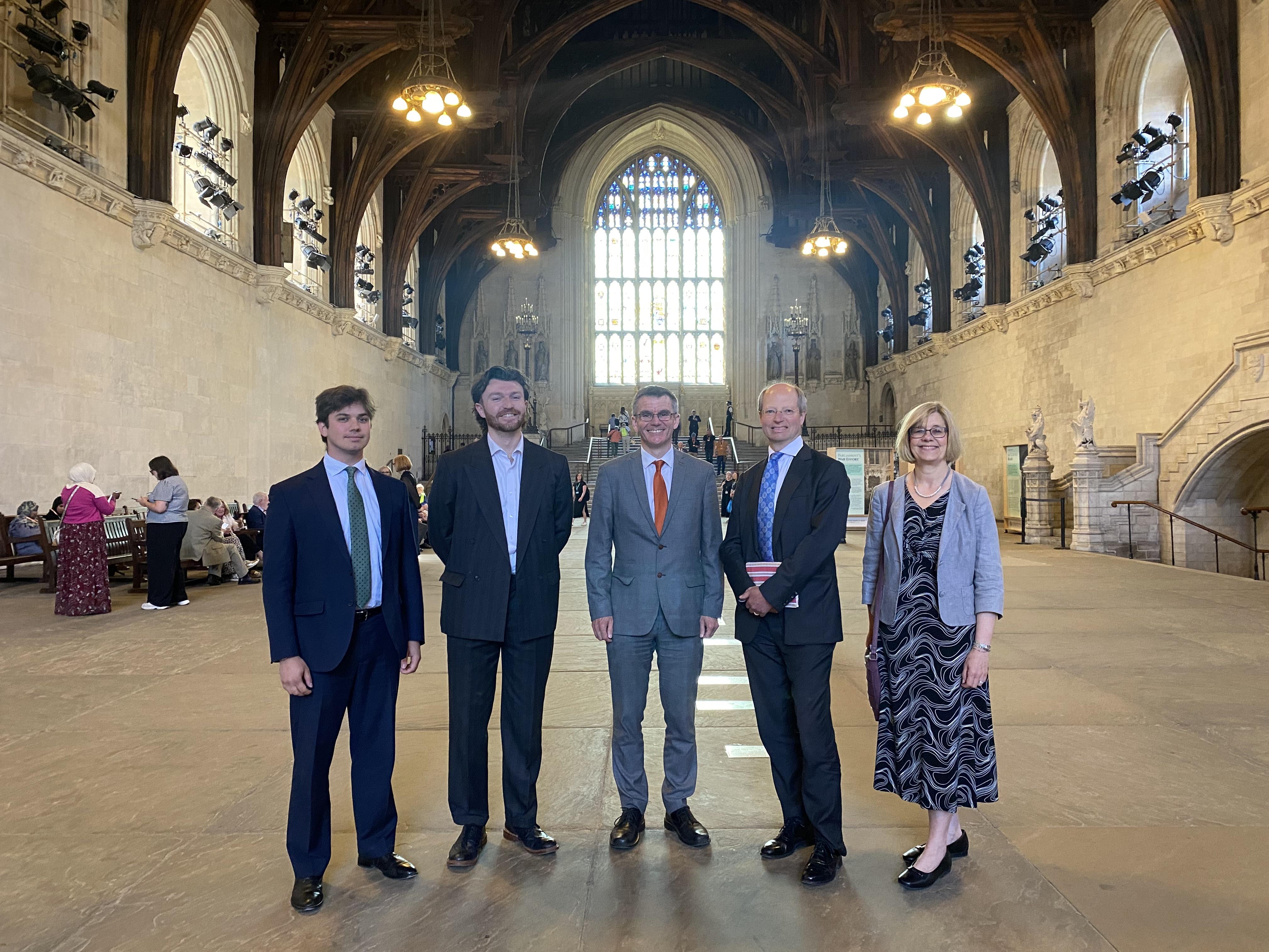 The National Churches Trust Public Affairs and Policy Team with our Chair, Sir Philip Rutnam, and Chief Executive Claire Walker inside Westminster Hall. A large arched window is behind the team.