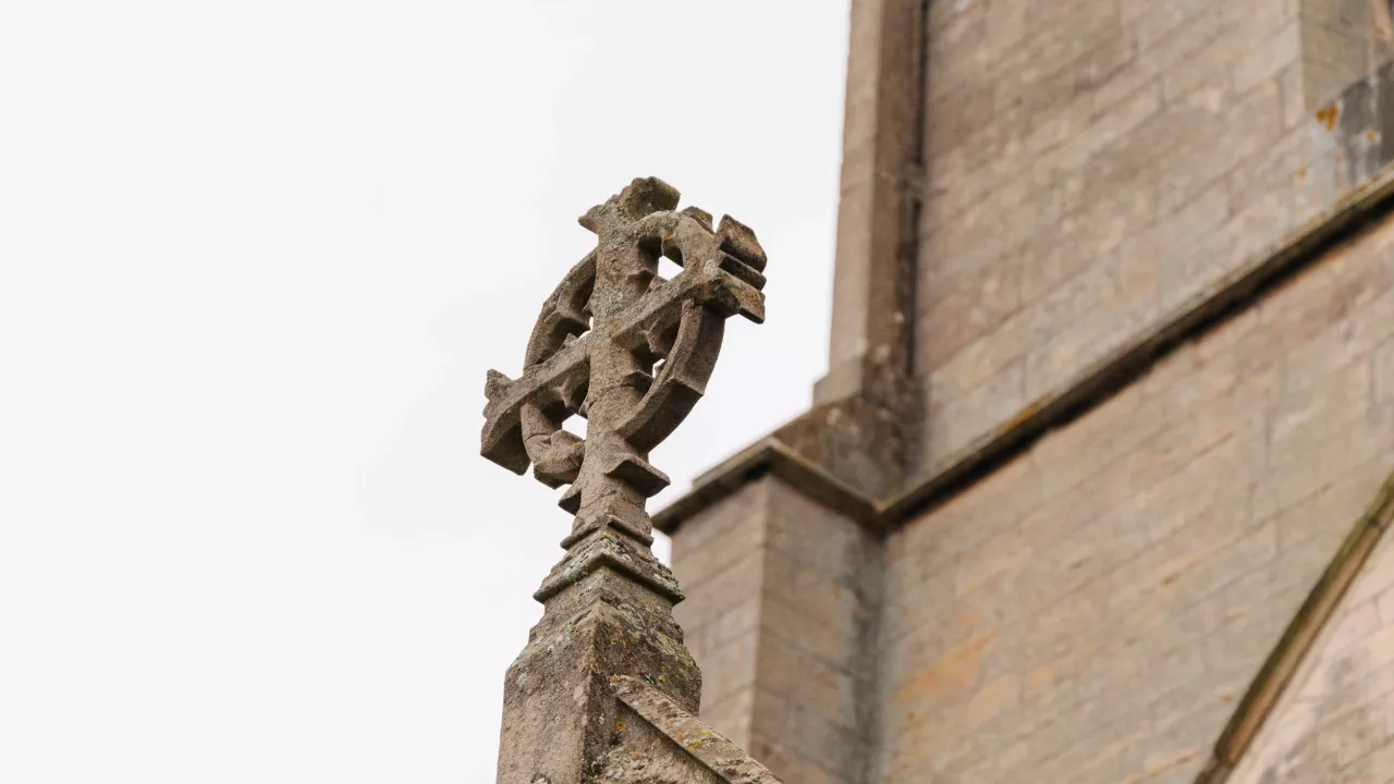 A stone cross on a church building