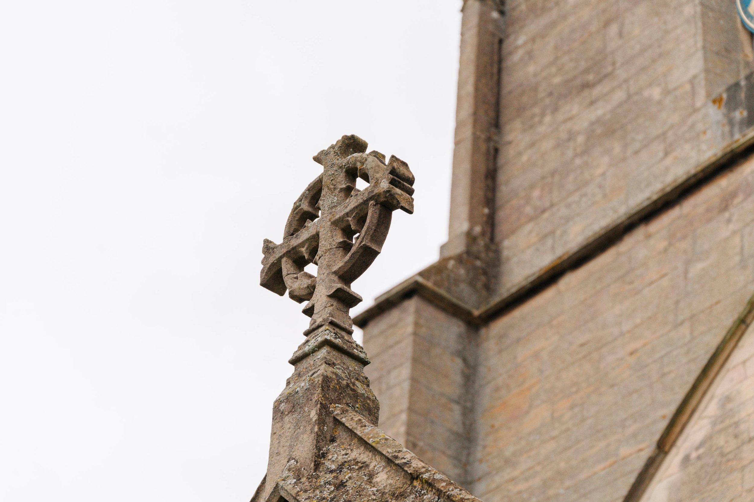 A stone cross on a church building