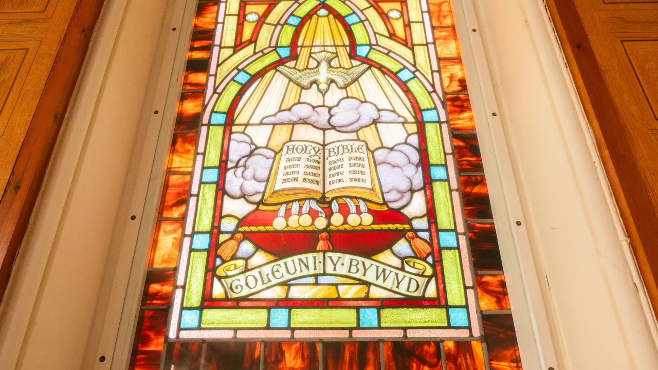 A bilingual stained glass window in Bethesda Presbyterian Chapel in Mold, Flintshire. It is brightly coloured.