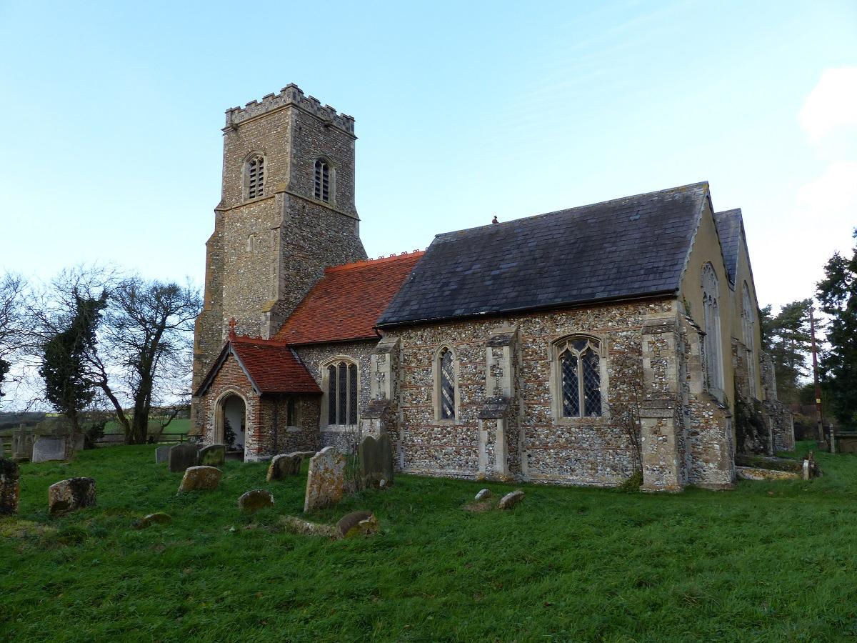 Exterior of St Margaret; a beautiful stone church with a tower on the left and a red roof.
