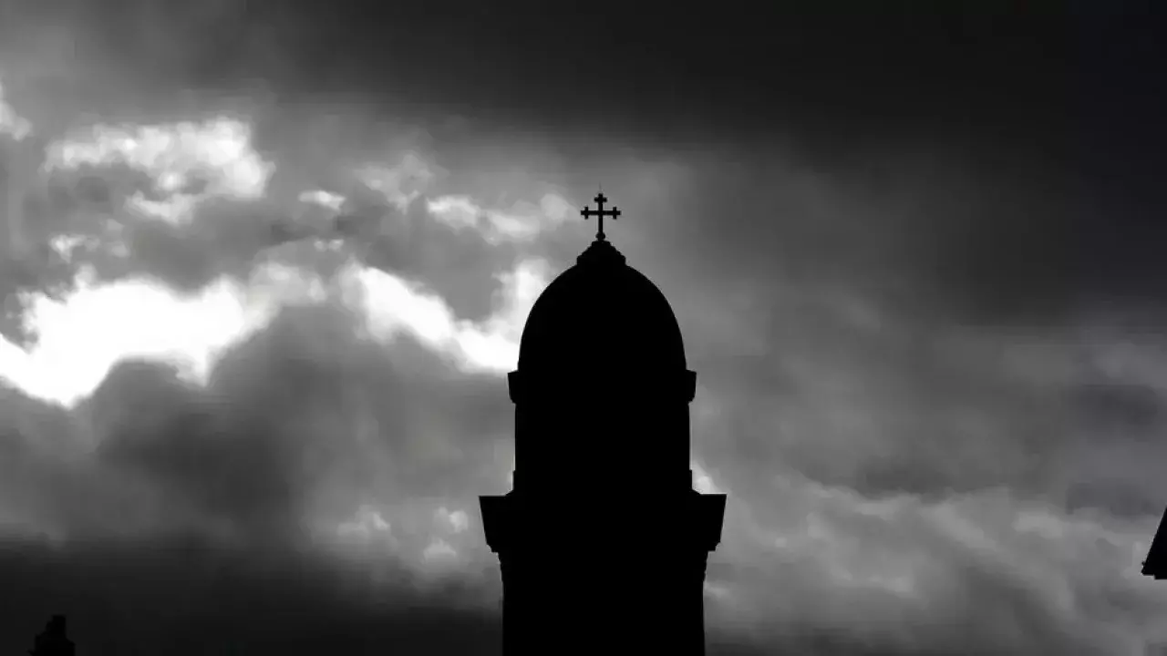 A black and white photo of the tower of Bridgenorth St Mary Magdalene with stormy skies surround it.